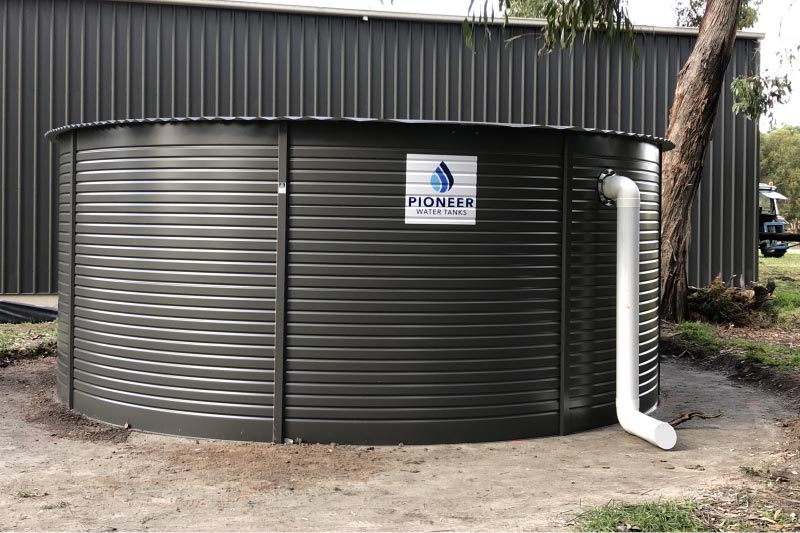 50,000lt Pioneer steel water tank in Colorbond colour Monument, beside shed.